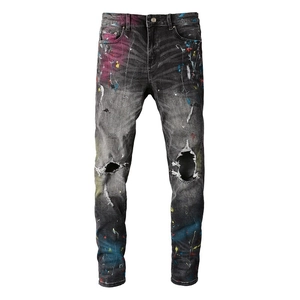 Black distressed slim fit denim jeans with colorful paint splatters and ripped knees