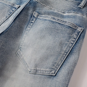Vue détaillée du plissé motard et du denim délavé bleu clair sur la poche arrière