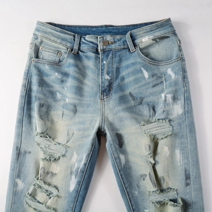 Vintage light blue ripped slim fit jeans with paint splatter and heavy distressing