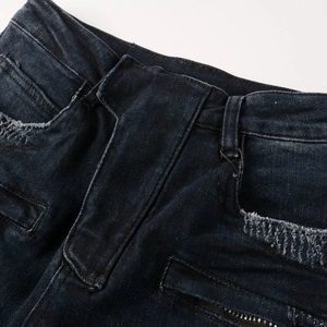 Detailed macro view of distressed denim texture with metal zipper and frayed pocket edge