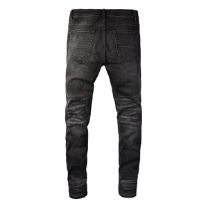 Detail view of the back of slim-fit men's denim jeans with washed texture and dual pockets