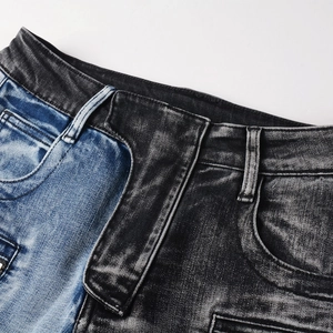 Detail shot of the two-tone distressed denim fabric with blue and grey patchwork texture