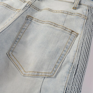 Detail of light blue denim with side wavy color-block tape and yellow stitching