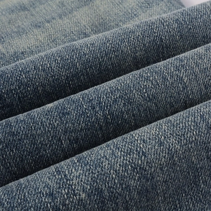 Close-up detail of blue denim fabric with twill weave texture and durable fiber structure