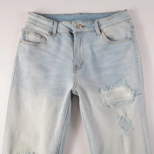Detailansicht der hellblauen Jeans mit Destroyed-Effekten und modischen Vintage-Flicken