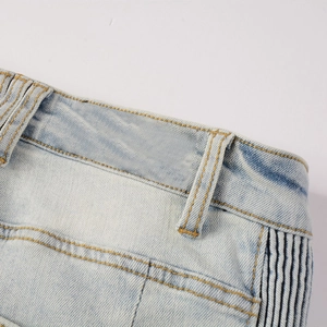Detailed close-up of light blue washed denim jeans with contrast stitching and side stripes