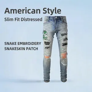 Jean déchiré slim bleu clair avec broderie serpent verte et empiècements peau de serpent