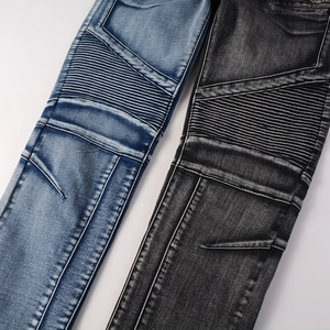 Detail showing moto-style ribbing and stitching on blue and black biker jeans