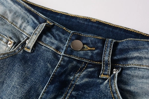 Close-up of classic blue denim jeans featuring contrast stitching and metal button