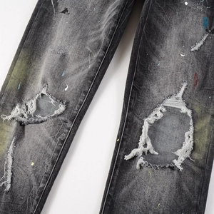 Slim fit distressed charcoal denim jeans with paint splatter and ripped knee details