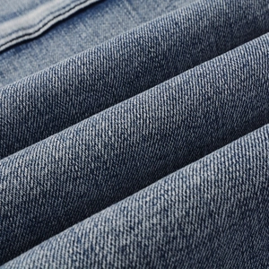 Macro shot of high-quality mid-blue twill denim fabric with natural wash texture
