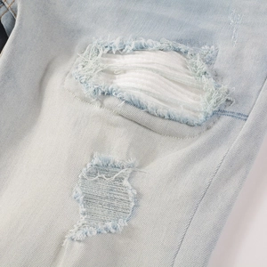Makrodetail der hellblauen Jeans mit Distressed-Löchern und weißem Stofffutter für Herren