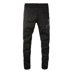 Détail de la broderie de cobra violet sur la poche arrière du jean noir slim fit