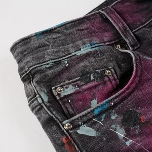 Men's high street distressed jeans with colorful artistic paint splatter and metal rivets