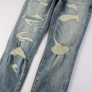 Detail of distressed ripped denim showing vintage light blue wash and fabric texture