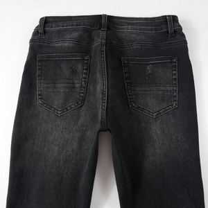 Vue détaillée du jean slim gris foncé délavé avec coutures et effets d'usure aux poches