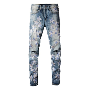 Detail der schmal geschnittenen Herrenjeans mit Stern-Patches und Rissen am Knie