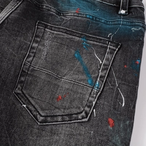 Detailed view of the distressed back pocket on men's streetwear graffiti splash jeans