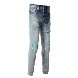Men's slim fit distressed blue jeans with ripped patchwork details and cat whiskers texture