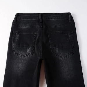 Detail shot of black washed denim fabric with vintage distressed texture and back pockets