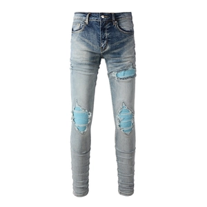 Slim fit light blue distressed jeans with ribbed patches and stacked ankles for men