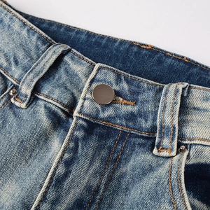 Detail of waist design on distressed denim jeans with metal button and belt loops