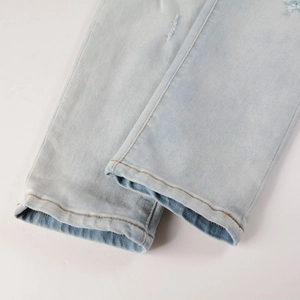 Detailaufnahme einer hellblauen Jeans mit Naht am Saum und gewaschener Texturierung