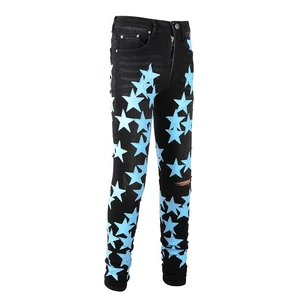 Dettaglio dei jeans neri slim fit con toppa a stella azzurra e design con strappi curati