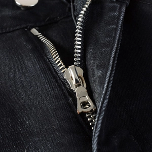 Detail of premium silver metal zipper on vintage washed black denim jeans for men