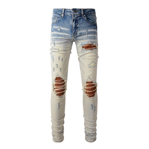 Détail macro du jean déchiré pour homme avec denim délavé et doublure intérieure rayée