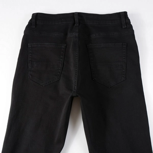 Macro view of men's black slim fit denim pants back waist and pocket detail