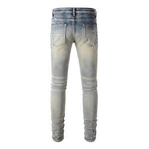 Detailed back view of light blue slim fit denim jeans with colorful paint splatter design