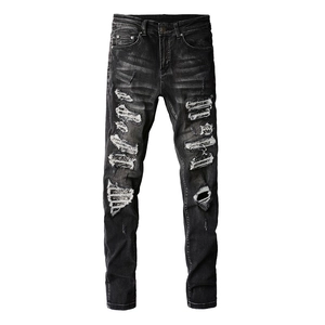 Jean slim noir pour homme avec détails déchirés et empiècements au style urbain tendance