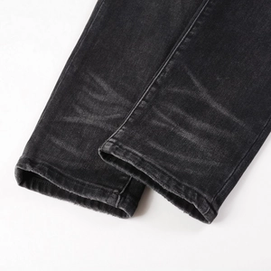 Jean noir slim avec texture délavée vintage et détails de l'ourlet effiloché sur le bas