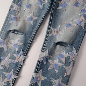 Detail der hellblauen Jeans mit Stern-Patches und Used-Effekt am Knie für Streetwear