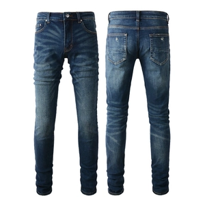 Macro detail of dark blue slim jeans showing whiskered fading and high-quality denim texture