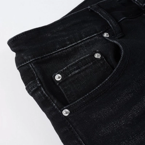 Dettaglio della vita in denim nero con rivetti in argento e cuciture rifinite