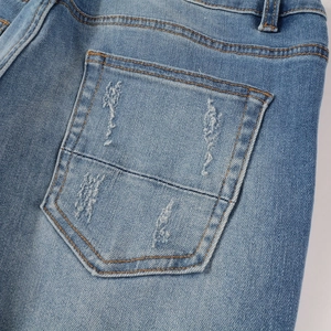 Macro detail of high street jeans back pocket with PU patch and distressed torn designs