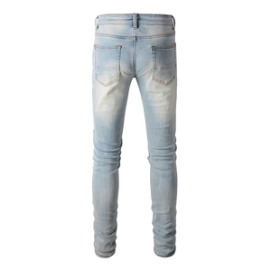 Detail view of the back of men's slim fit jeans with faded wash and pocket stitching