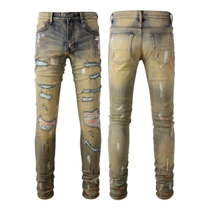 Detailansicht der Retro-Jeans mit gelber Waschung, Löchern und Farbspritzer-Effekt