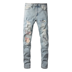 Slim fit men's distressed jeans with light blue gradient wash and ripped patch details