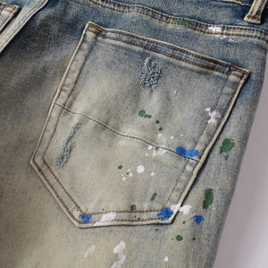 Men's slim fit distressed blue jeans with vintage wash and colorful paint splatter