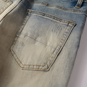 Gros plan sur la poche arrière usée du jean slim en denim bleu clair délavé vintage