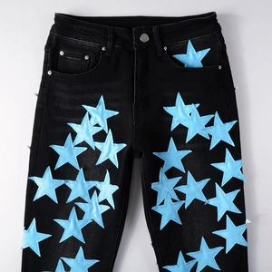 Dettaglio di stelle in pelle blu con cuciture bianche su jeans in denim nero