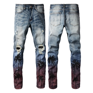 Close-up of slim fit distressed jeans with palm tree prints and red-brown gradient dye