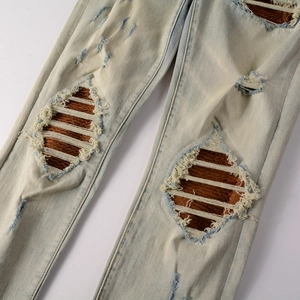 Vue détaillée du jean bleu clair avec patchs en velours marron et effets d'usure