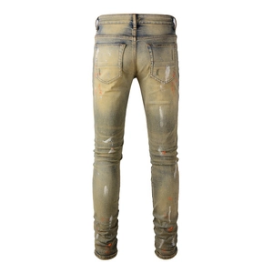 Detailansicht der Gesäßtasche der Slim-Fit-Jeans mit Gelbwäsche und Farbspritzern