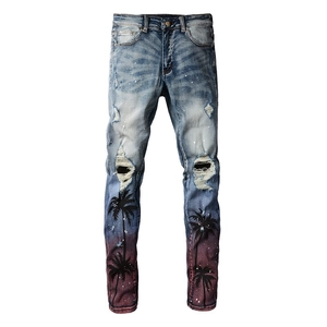 Slim fit light blue distressed jeans with palm tree print and gradient hem detail