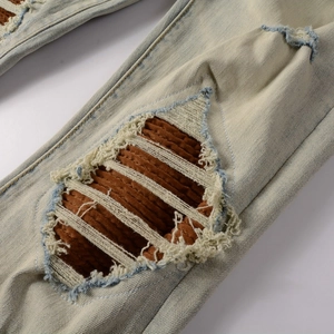 Détail du denim vieilli avec empiècements en velours côtelé et bords effilochés