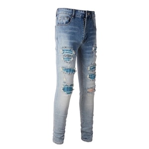 Men's slim-fit distressed jeans in light blue with ripped patchwork and rhinestones